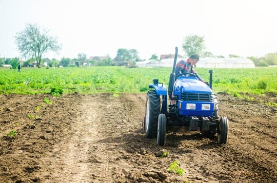a-driver-on-a-farm-tractor-performs-land-work-on-t-2022-11-09-06-32-04-utc